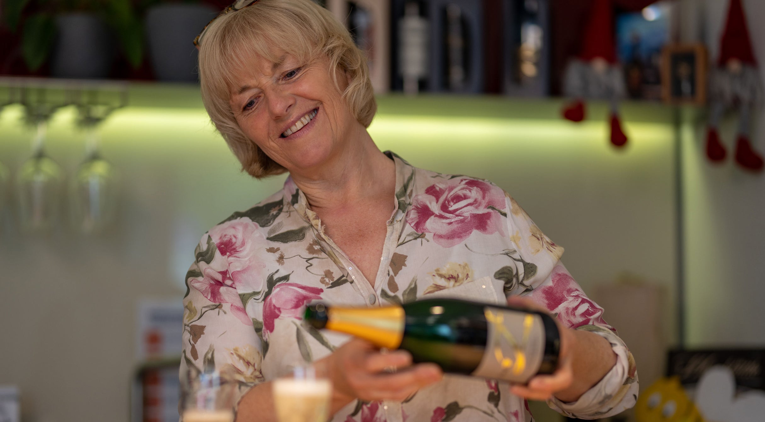 Zu sehen ist Sonja Zaiss beim einschenken eines Glases Sekt in der Vinothek. Folgende persönliche Beschreibung dazu: SONJA ZAIß "UNSEREN GÄSTEN & KUNDEN MIT MEINEM FRIESISCH-SCHWÄBISCHEN CHARME EIN LÄCHELN INS GESICHT ZU ZAUBERN, IST MEIN TÄGLICHES ZIEL."
