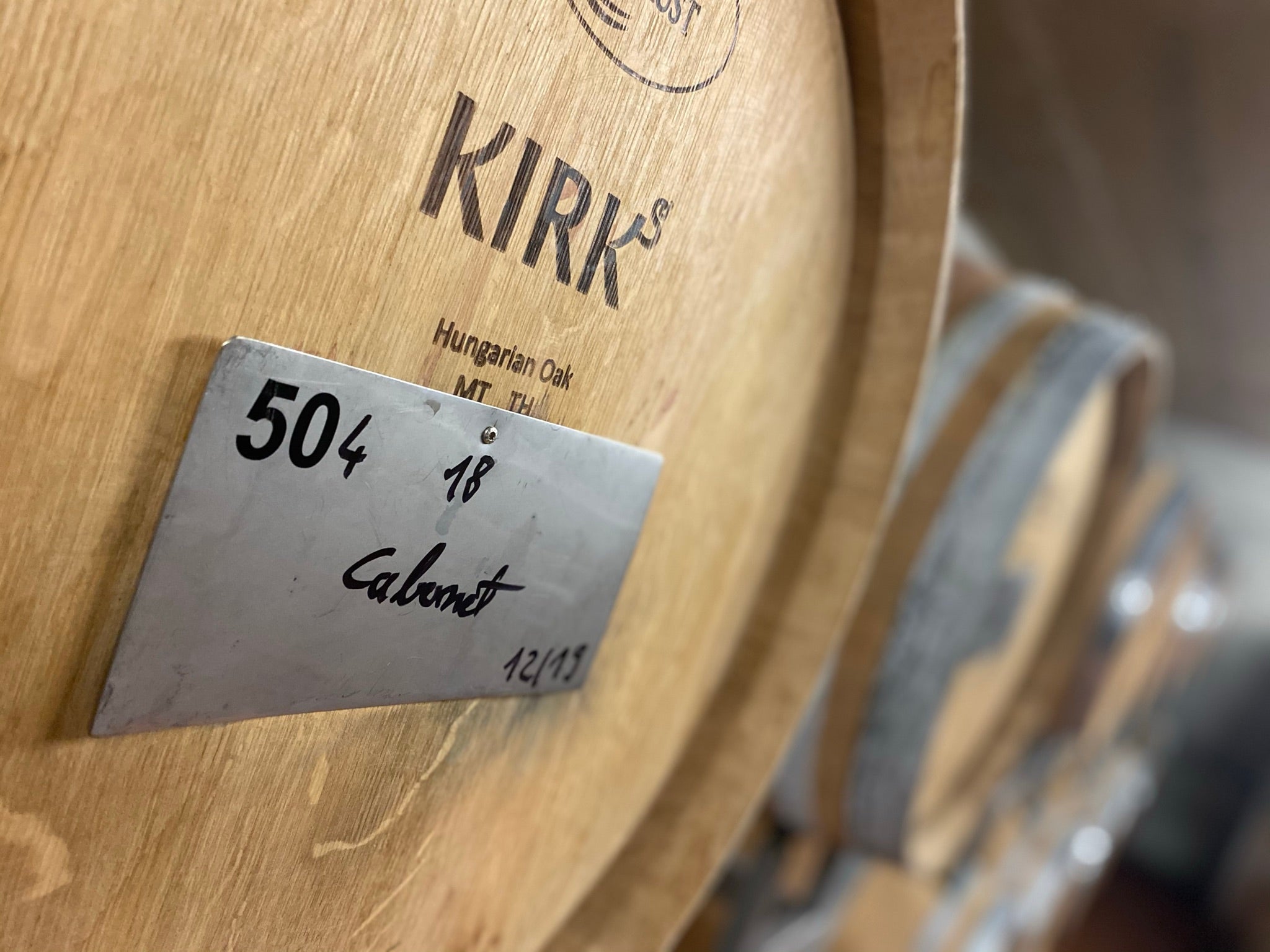 Zu sehen sind Holzfässer zum Weinausbau. Passend zum Text auf dem Bild "Jedes leere Weinfass steckt voller Geschichten."